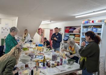 People gathered in a room working on individual crafting projects
